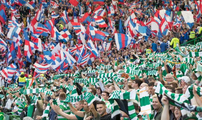 Fans of Celtic and Rangers, Glasgow's two football teams, cheer at the start of a match in 2016. Getty Images