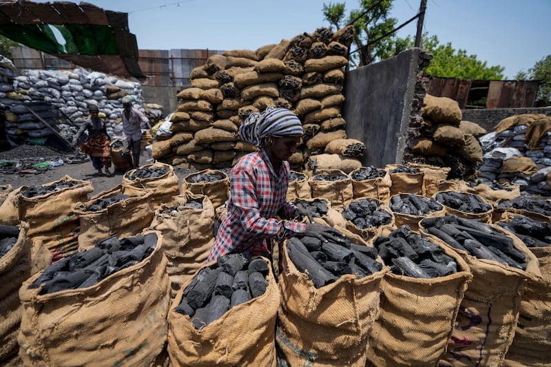 A woman works at a coal depot in Ahmedabad, India, in May. AP Photo