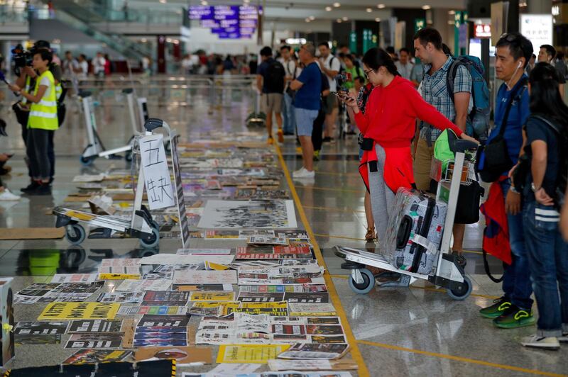 Travellers look at placards and posters placed by protesters at the airport in Hong Kong. AP Photo