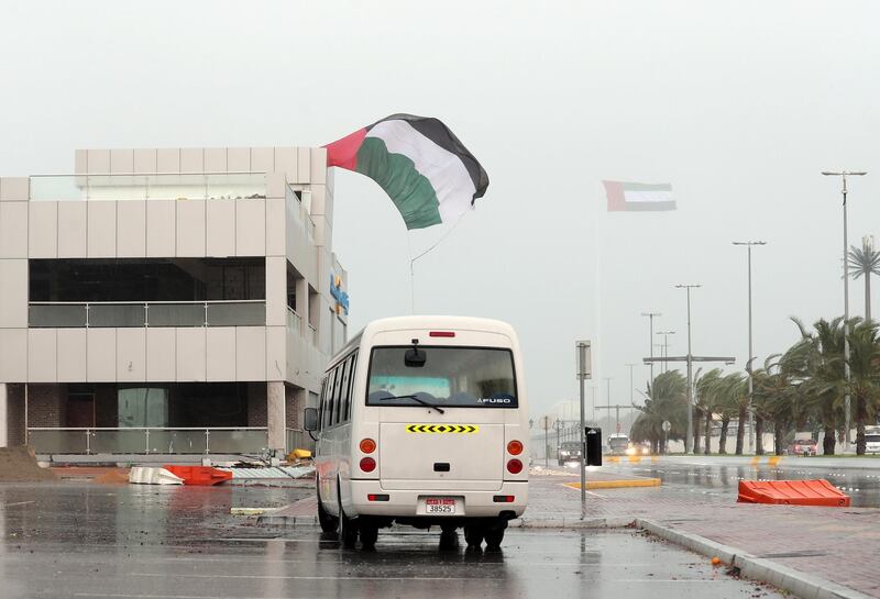 Abu Dhabi, United Arab Emirates - November 10, 2019: A flag comes partly free from a building as dark clouds and rain batter the Abu Dhabi Coast. Sunday the 10th of November 2019. Abu Dhabi. Chris Whiteoak / The National