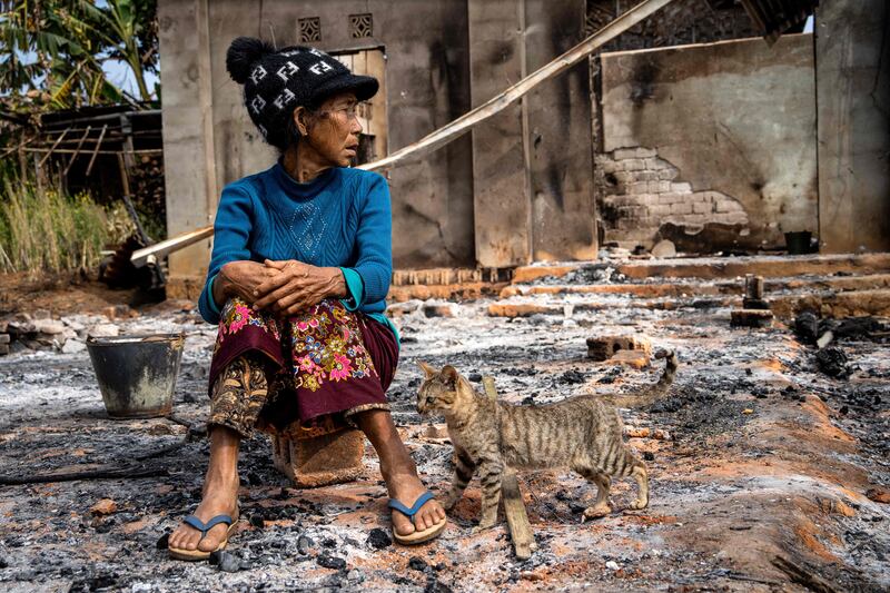 A woman sits outside her damaged house after fighting between the military and the Kachin Independence Army in Nam Hpat Kar, Myanmar. AFP