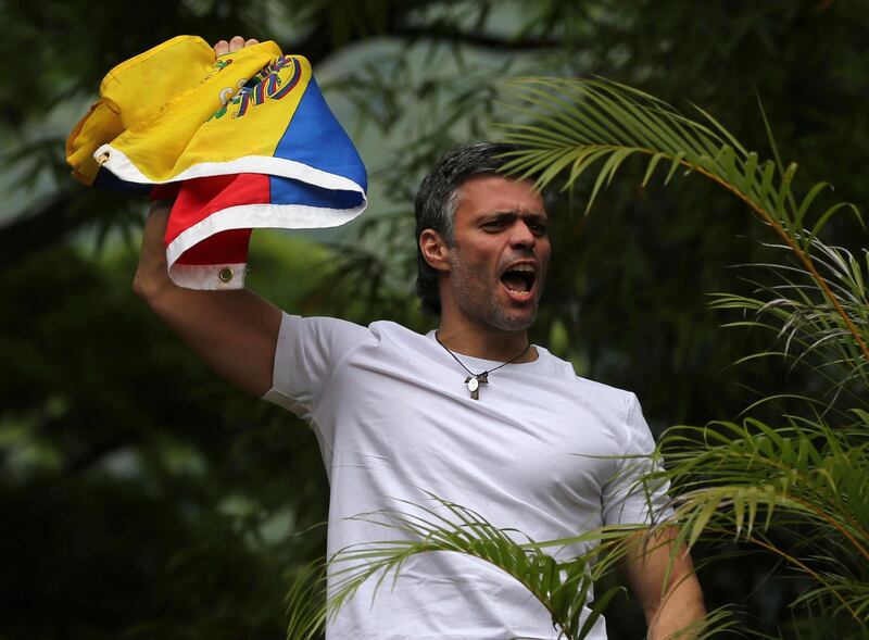 Opposition leader Leopoldo Lopez holds a Venezuelan national flag as he greets supporters outside his home in Caracas (AP Photo/Fernando Llano)