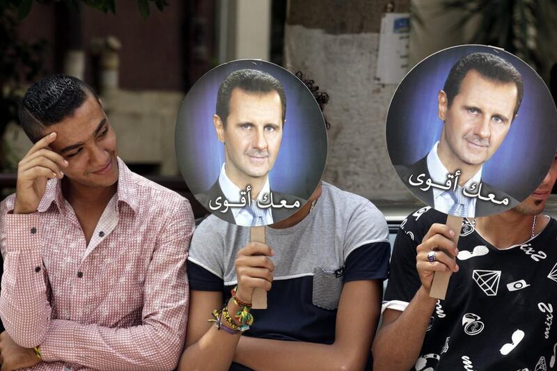 Syrians living in Egypt hold portraits of President Assad as they gather to support the Syrian presidential elections outside the Syrian Consulate in Cairo, Egypt. Amel Pain / EPA