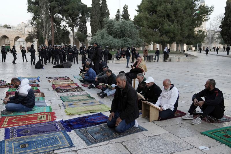 Palestinian worshippers pray as Israeli police officials stand guard at Al Aqsa Mosque compound. AP