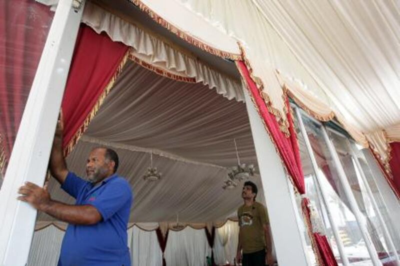 Dubai, United Arab Emirates- July 19,  2011:  (R)  Said Mohammed Ghaniullah, Project Co-ordinator, Mumtaz Tents monitors  during setting up the Ramadhan Tents at the Dubai Marina in   Dubai.  ( Satish Kumar / The National )