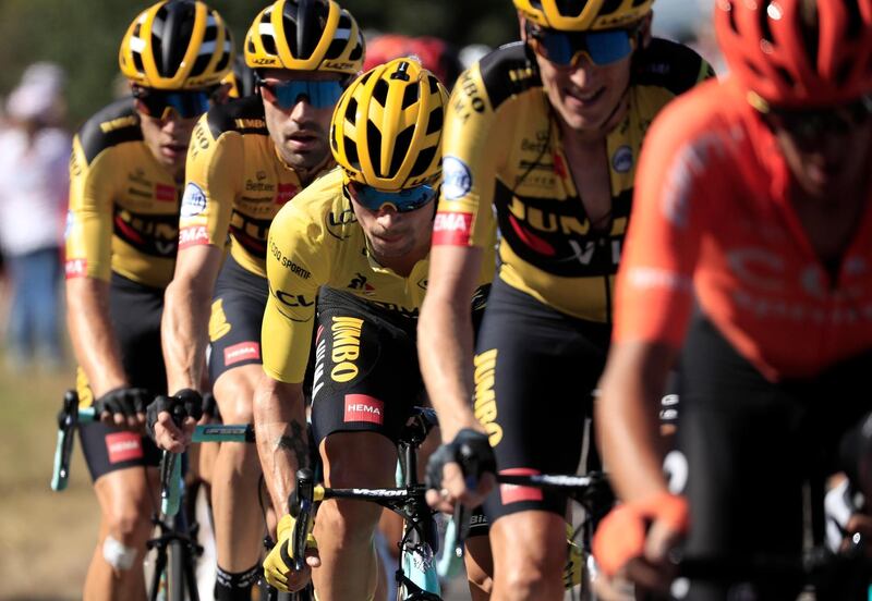 Slovenian rider Primoz Roglic, centre, wears the overall leader's yellow jersey. EPA