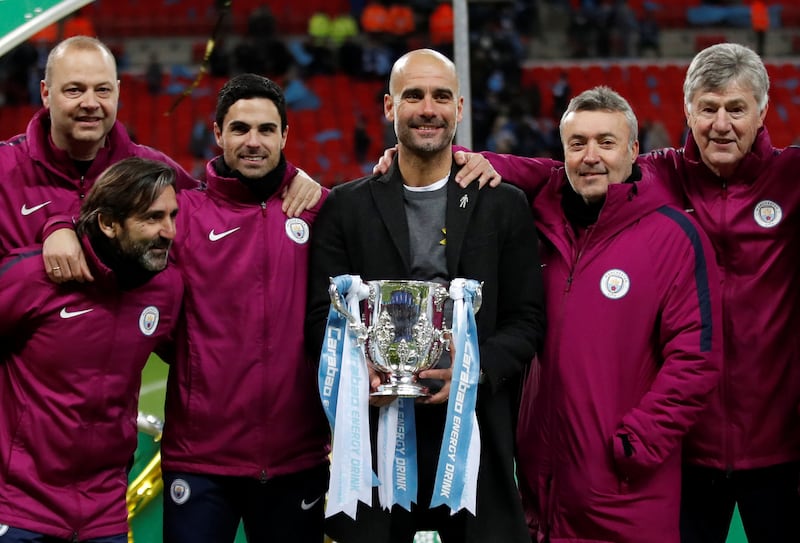 Pep Guardiola and his staff celebrate with the trophy after winning the League Cup at Wembley Stadium in 2018. Reuters