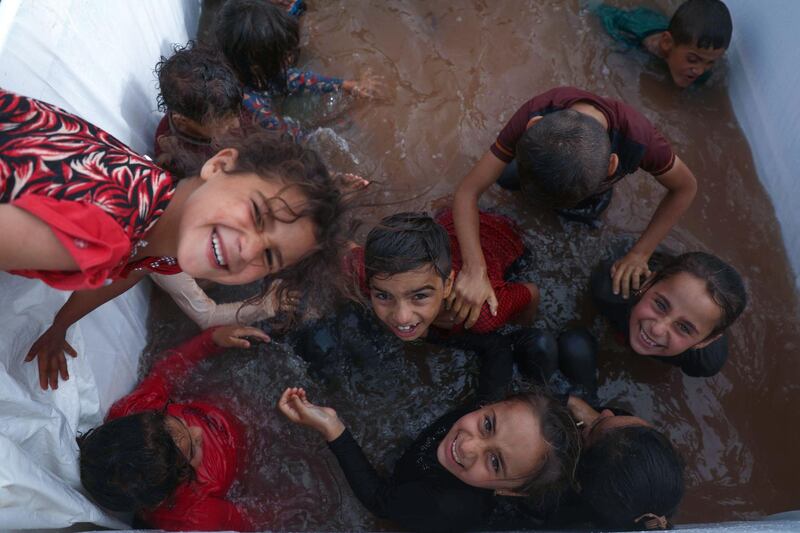 Children play in a mobile makeshift pool on the back of a pick-up truck amid the heat, at a camp for the internally displaced near the village of Killi in the north of the northwestern Idlib province. AFP