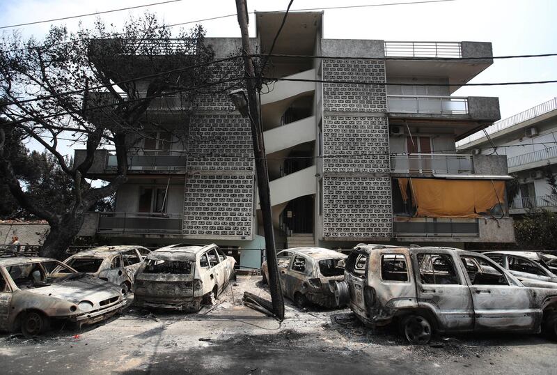 Burned-out cars stand outside an apartment block in Mati. AP Photo