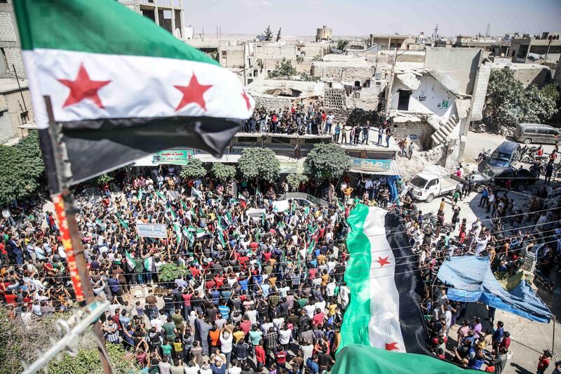 People carry Syrian revolution flags and placards during protests in Kafr Nabl town, Maarrat al-Nu'man District, rebels-held Idlib province, Syria. EPA