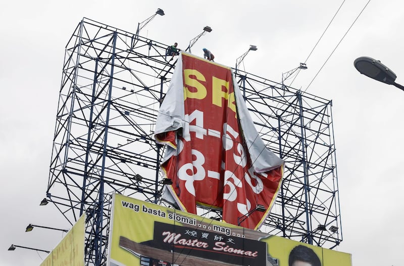 Workers remove a billboard advertisement in preparation for typhoon Vongfong in Quezon City, Metro Manila, Philippines.  EPA