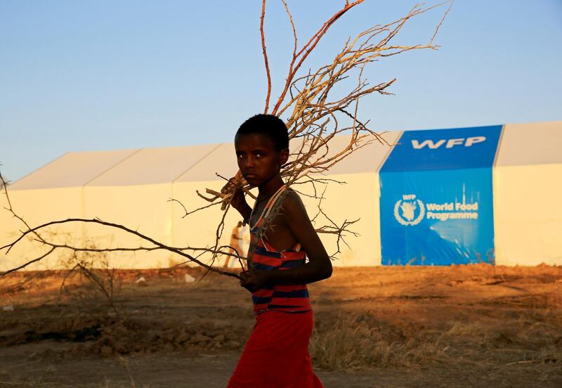 An Ethiopian refugee fleeing from the ongoing fighting in Tigray region, walks past a world food program tent, at the Um-Rakoba camp, on the Sudan-Ethiopia border, in the Al-Qadarif state, Sudan November 23, 2020. Picture taken November 23, 2020. REUTERS/Mohamed Nureldin Abdallah
