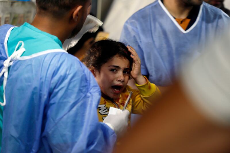 Palestinian medics at the Kuwait Hospital in Rafah refugee camp treat a girl injured in Israeli bombing on Tuesday. AP Photo