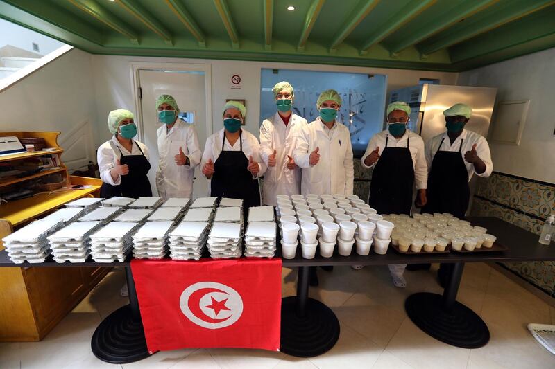 Tunisian cooks pose for a photo after preparing meals for the underprivileged at the Dar Slah restaurant in the medina of Tunis, Tunisia.  EPA