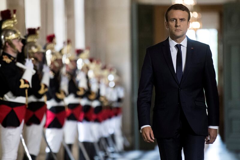 FILE PHOTO: French President Emmanuel Macron  walks through the Galerie des Bustes (Busts Gallery) to access the Versailles Palace in July 2017.   REUTERS/Etienne Laurent/Pool/File Photo