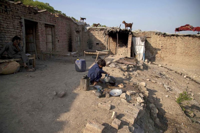 Samiullah, who says he is 14 years old, washes dishes at a coal mine in Choa Saidan Shah, Punjab. Sara Farid / Reuters