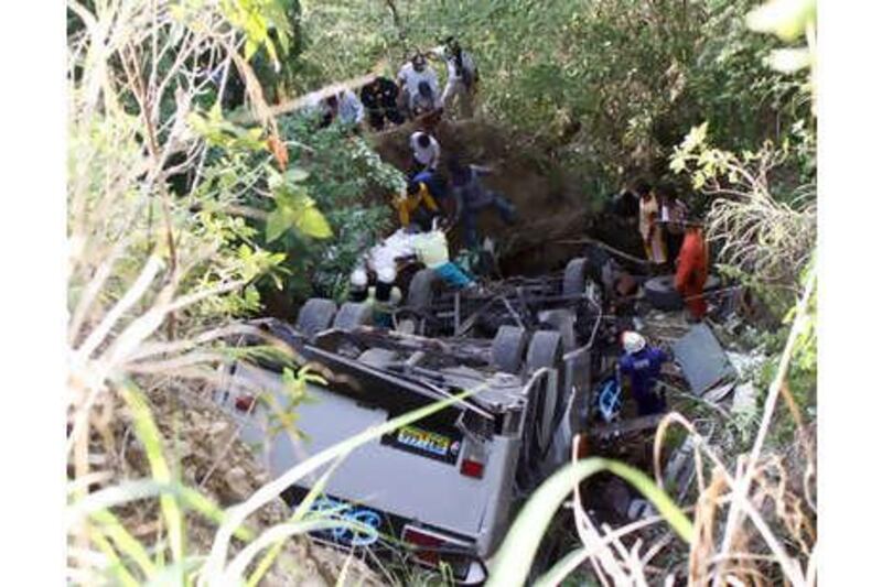 Rescuers recover victims from the wreckage of a bus that fell into a ravine in Balanban, Cebu in central Philippines on Sunday, June 13, 2010.