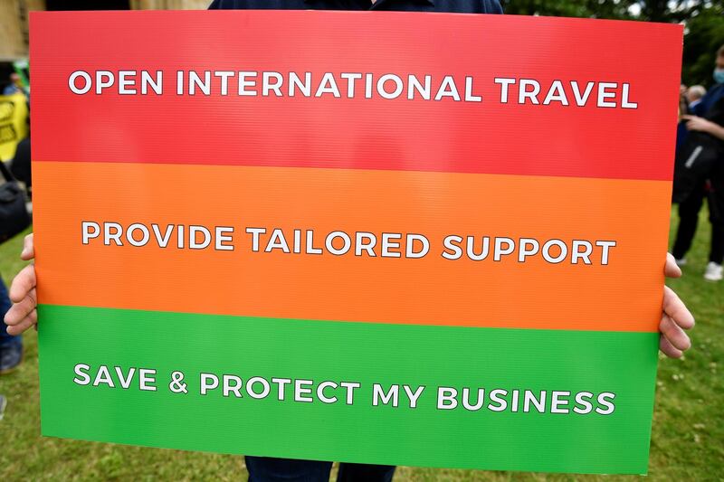 A person holds a placard during a demonstration against the current coronavirus disease travel restrictions, in London. Reuters