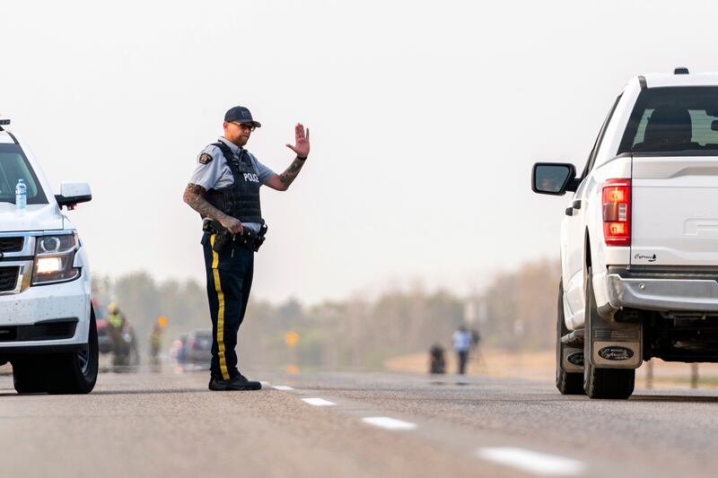 A police officer issues instructions to a driver on a road outside Rosthern, Saskatchewan. AP