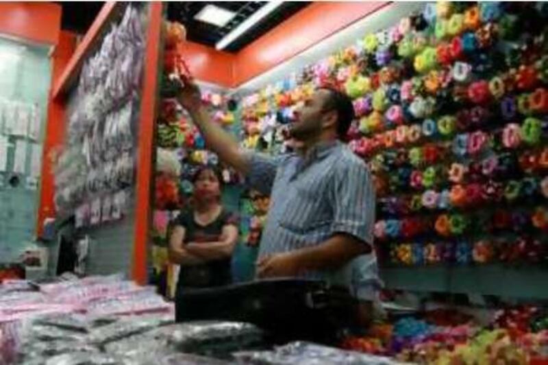 A Middle Eastern trader examines goods in Yiwu's vast Futian commodity market.

Credit: Tom Spender/The National *** Local Caption ***  Yiwu6.JPG