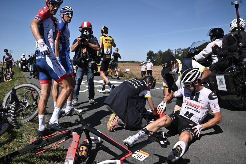 Nicolas Roche is helped by medics after crashing. AFP