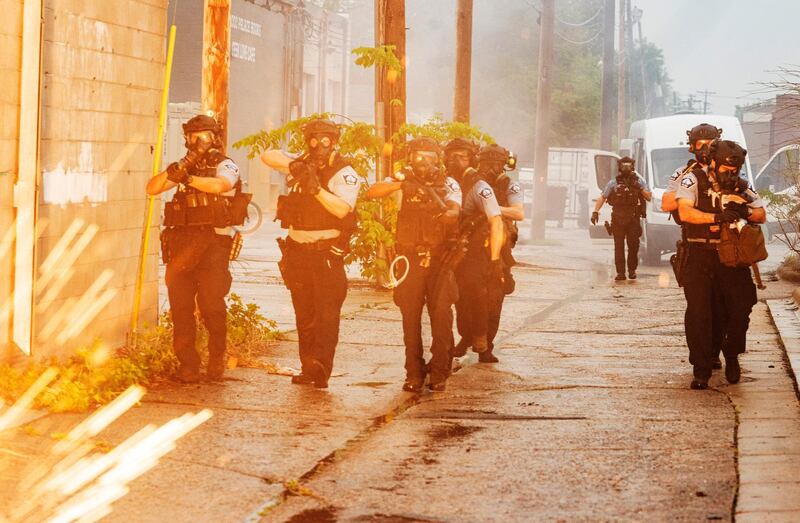 Police officers deploy to disperse protesters gathered for George Floyd in Minneapolis.  AP