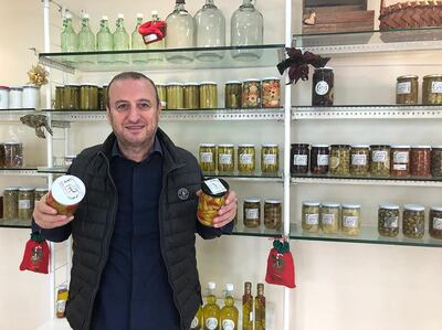 Fares Abou Merhi holds jars of pickles, his new line of work after his former company went out of business. Aya Iskandarani 
