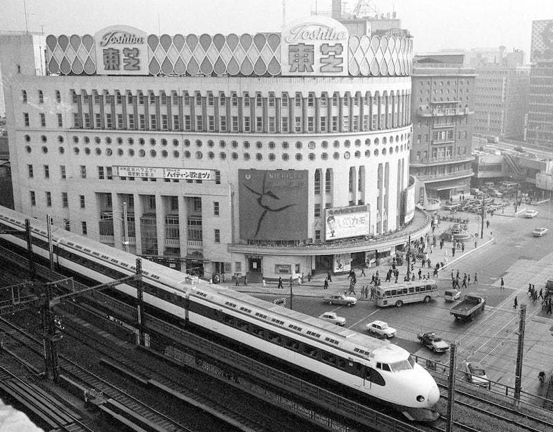 A Shinkansen train passes by Nichigeki Theater in the Yurakucho district shortly after leaving Tokyo Station in 1964. AP Photo