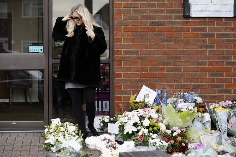 One of Sir David Amess's daughters views flowers and tributes left for her late father at Belfairs Methodist Church. AP