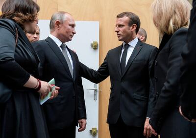 Russian President Vladimir Putin (L) talks with his French counterpart Emmanuel Macron next to Brigitte Macron after they attended a church service for former French President Jacques Chirac at the Saint-Sulpice church in Paris, on September 30, 2019. Former French President Jacques Chirac died on September 26, 2019 at the age of 86. / AFP / Sputnik / Alexei Druzhinin
