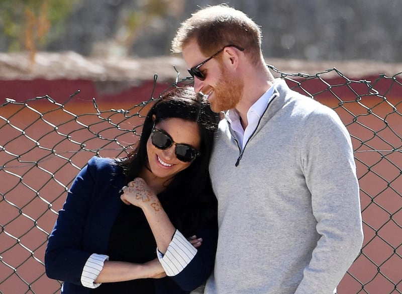 FILE - In this Sunday, Feb. 24, 2019 file photo, Britain's Prince Harry and Meghan, Duchess of Sussex, watch children playing football at a school in the town of Asni, in the Atlas mountains, Morocco. Buckingham Palace said Monday May 6, 2019, that Prince Harry's wife Meghan has gone into labor with their first child. (Facundo Arrizabalaga/Pool via AP, File)