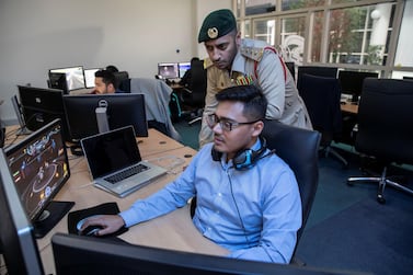Captain Dawood Mohammed oversees the work of a designer at Dubai Police's own in-house game development centre. Antonie Robertson/The National    