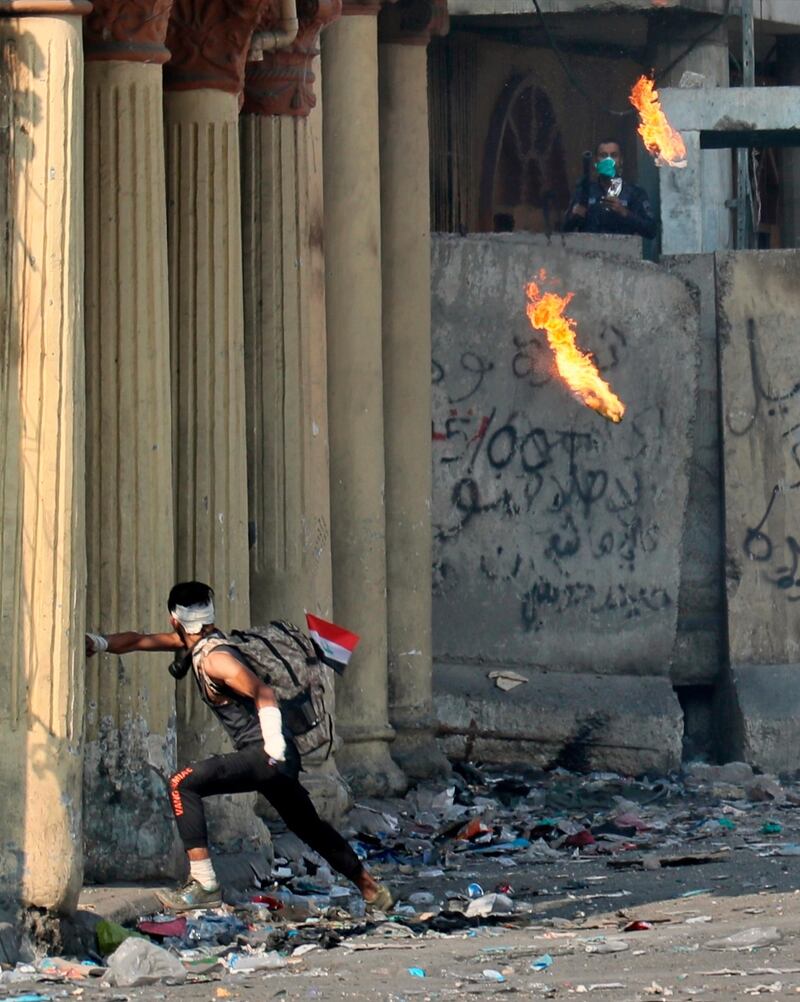 An anti-government protester throws a Molotov cocktail toward riot police during clashes on Rasheed Street, Baghdad. AP Photo