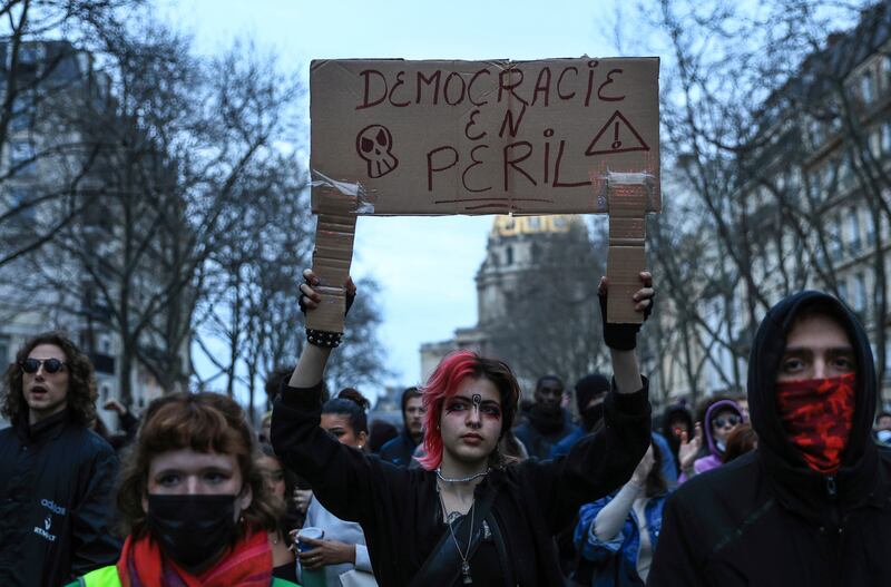 A demonstrator holds a placard that reads "democracy in danger" in Paris on Monday. AP