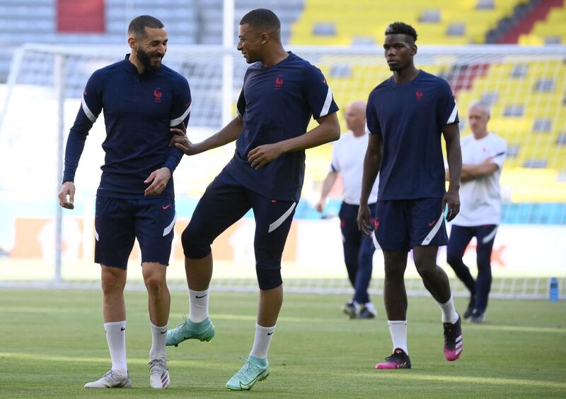 Kylian Mbappe talks with Karim Benzema as Paul Pogba follows them during a training session at the Allianz Arena. AFP