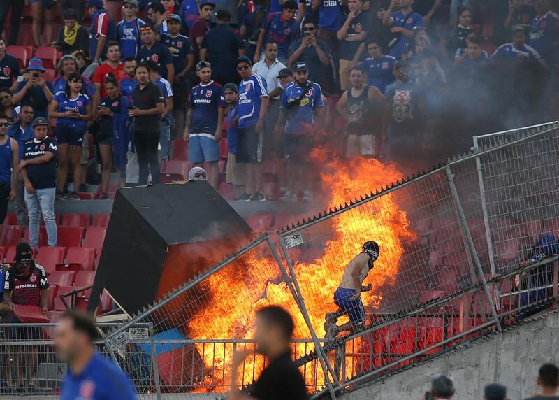 Universidad de Chile supporters start a fire in  the stands during the Copa Libertadores football match against Brazil's Internacional at the National stadium in Santiago on Tuesday, February 4. They were part of a wave of protests across the country against President Sebastian Pinera. Reuters