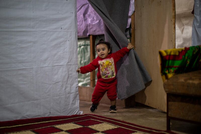 Rayan, an 18-month-old Syrian refugee, plays inside her parents' tent before they break their Ramadan fast at a makeshift refugee camp, in the town of Bhannine in the northern Lebanese city of Tripoli. AP Photo