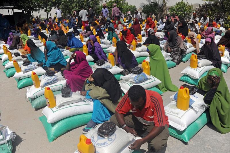 Somali internally displaced people (IDP) receive food aid donated by a Qatari charity during the holy Muslim month of Ramadan in Mogadishu, Somalia on June 20, 2015. Aid is distributed to the poor and needy in the month of Ramadan, where believers fast from sunrise to sunset. Mohamed Abdiwahab / AFP photo