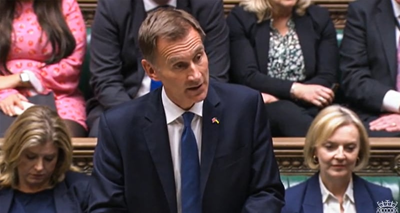 Britain's new Chancellor of the Exchequer Jeremy Hunt announcing tax and spending measures at the House of Commons in London, with Liz Truss sitting on the bench behind him. AFP