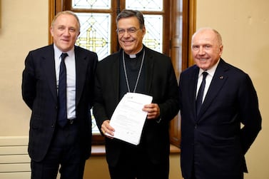 Francois-Henri Pinault, chief executive of French luxury group Kering, left, his father Francois Pinault, right, and Archbishop of Paris Michel Aupetit, centre, after signing an agreement October 1 to donate €100m towards rebuilding Notre Dame cathedral. Photo: AP