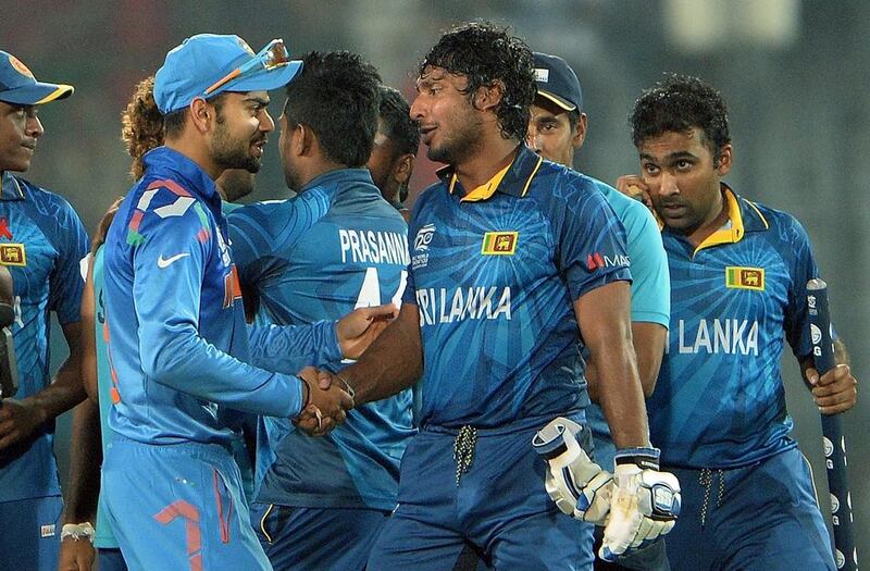 Sri Lanka batsman Kumar Sangakkara (C) is greeted by India player Virat Kohli (L) after Sri Lanka won the ICC World Twenty20 cricket tournament final match against India at The Sher-e-Bangla National Cricket Stadium in Dhaka on April 6, 2014. Sri Lanka won by six wickets.    AFP PHOTO/ PUNIT PARANJPE