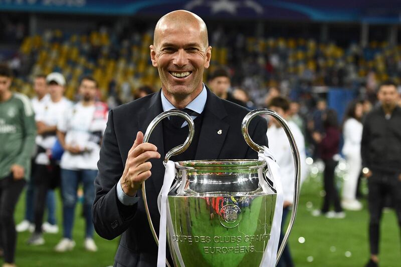 TOPSHOT - Real Madrid's French coach Zinedine Zidane holds the trophy as he celebrates winning  the UEFA Champions League final football match between Liverpool and Real Madrid at the Olympic Stadium in Kiev, Ukraine, on May 26, 2018. / AFP / FRANCK FIFE
