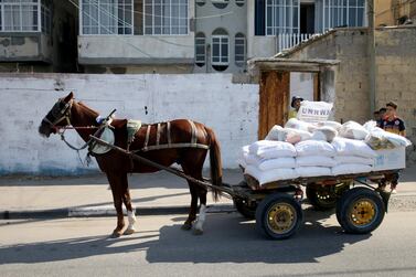 A Palestinian worker carries food supplies distributed by UNRWA in Gaza City. Reuters