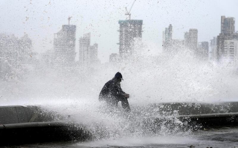 A man enjoys high tide waves on the Arabian Sea coast during monsoon rains in Mumbai.  AP Photo 