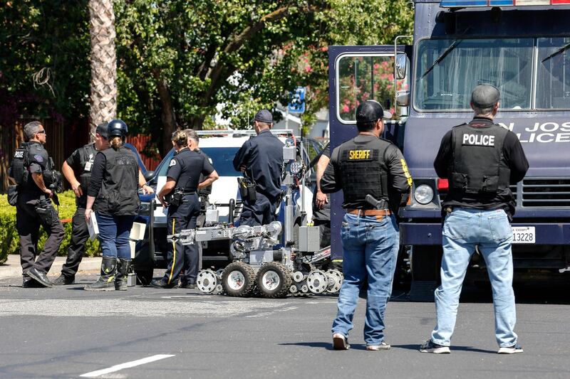 Emergency personnel and a bomb squad gather after a fire at the house of the suspected gunman. AFP