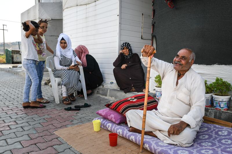 A Syrian refugee family sits in front of their home. Getty Images