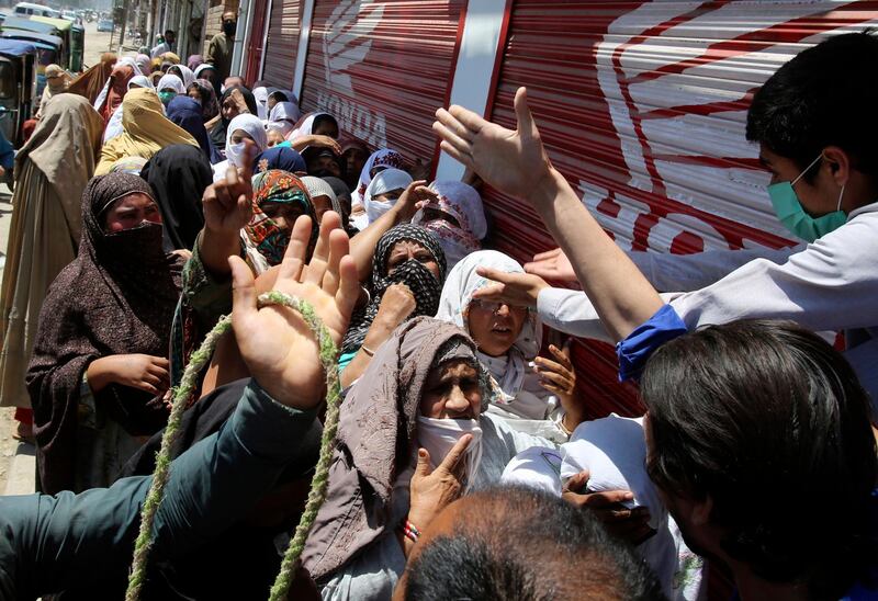 Women wait to receive free food in Peshawar, Pakistan. AP Photo