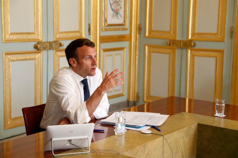 French President Emmanuel Macron, attends a video conference call with French virologist and President of the Research and Expertise Analysis Committee (Comite Analyse Recherche et Expertise, CARE) Francoise Barre-Sinoussi on ongoing efforts to accelerate the development and access to vaccine and treatment against the coronavirus at the Elysee Palace in Paris, Thursday, April 16, 2020. (Yoan Valat/Pool Photo via AP)