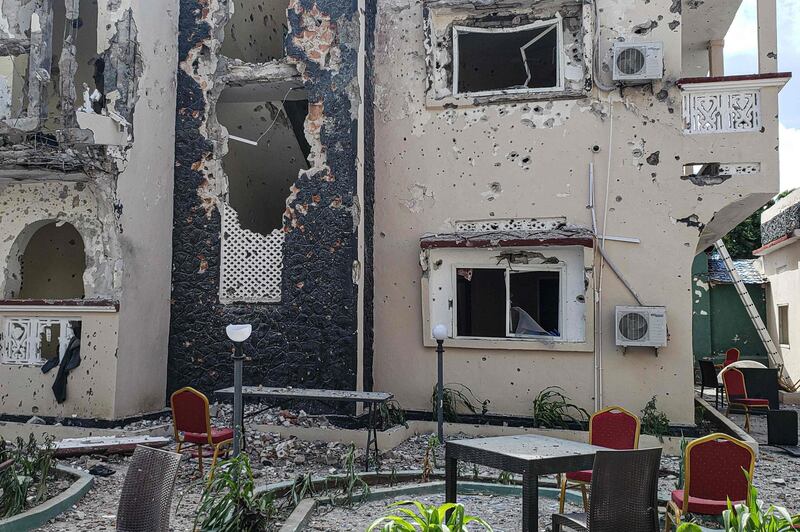 A man passes in front of the rubble of the popular Medina hotel of Kismayo.  AFP