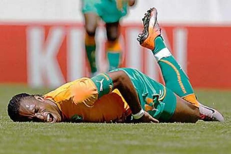 The Ivory Coast forward Didier Drogba, reacts in pain as he goes down during a friendly game against Japan at the Stade de Tourbillon in Sion.